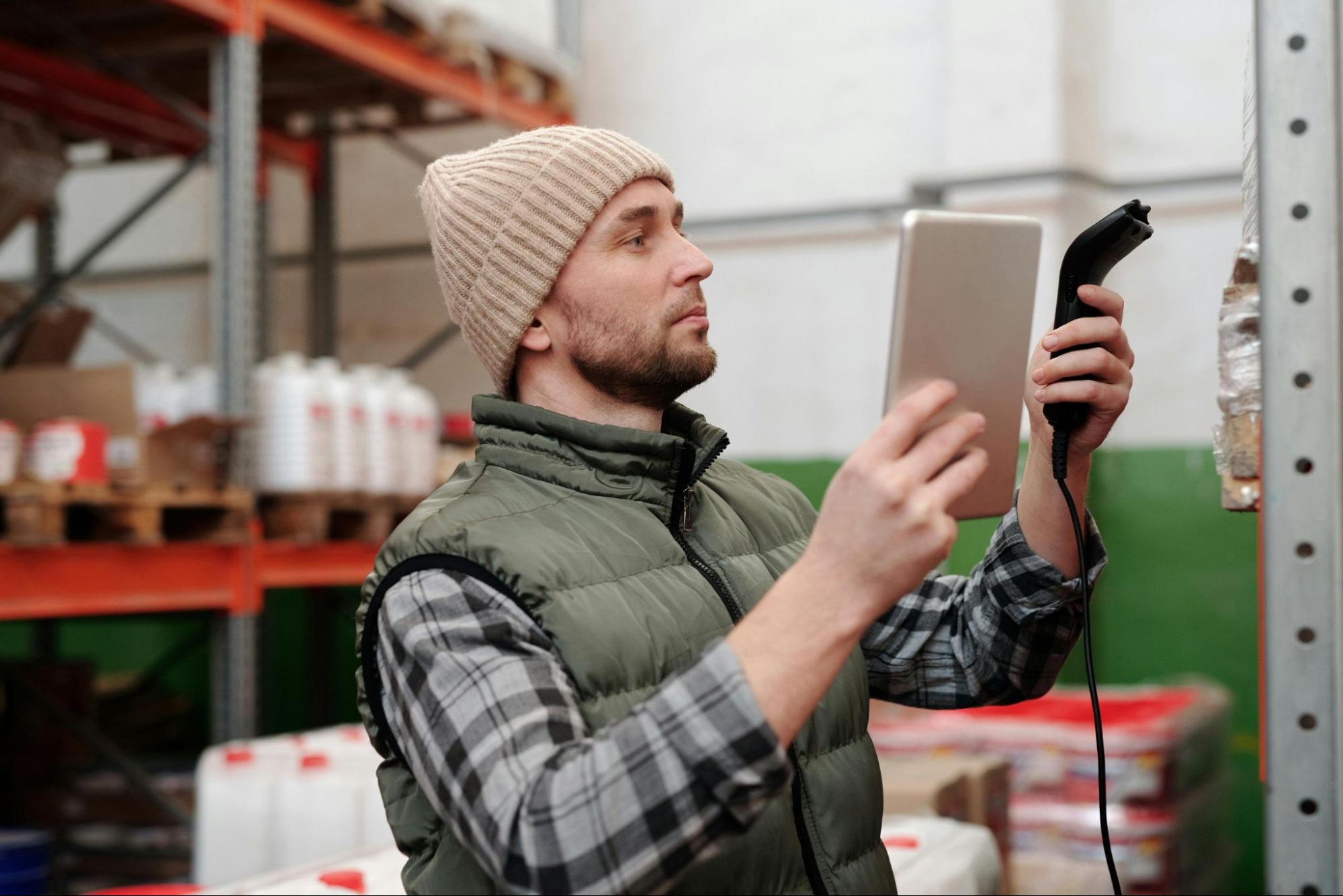 A warehouse worker scans packages – Trackonomy