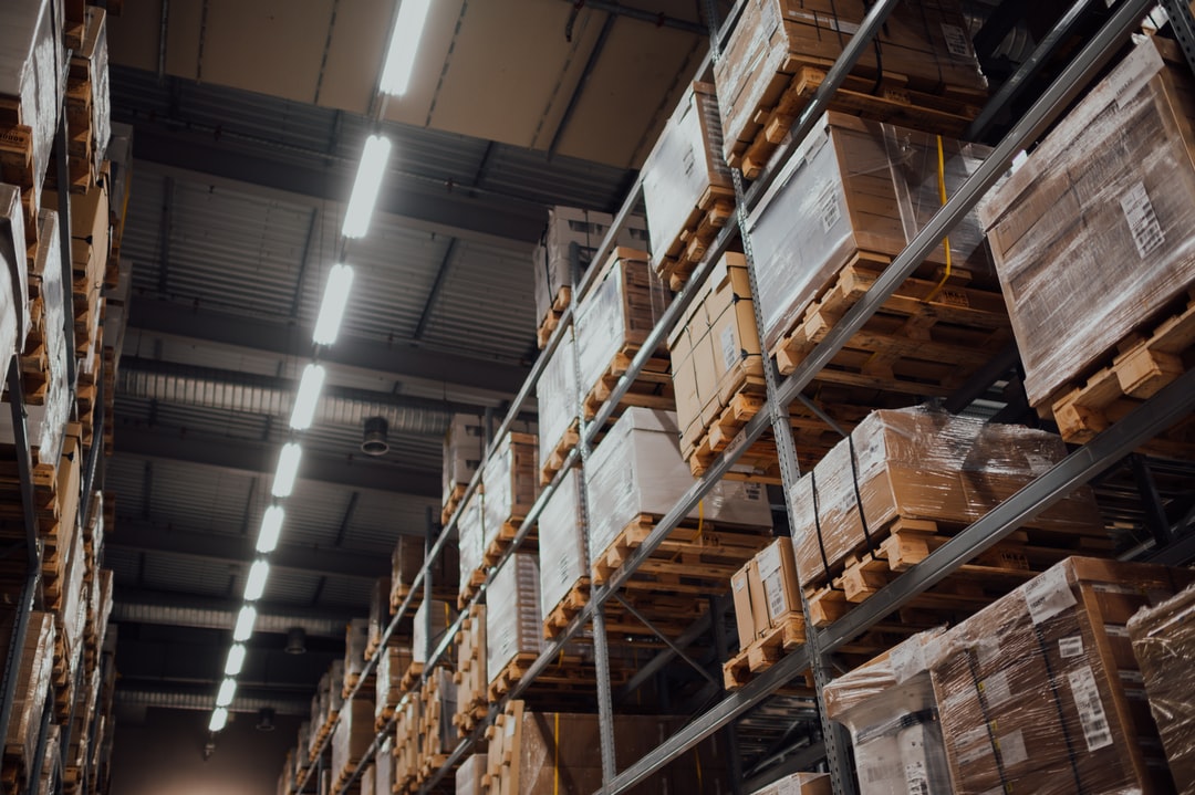 Many cardboard boxes stacked on shelves in a warehouse.