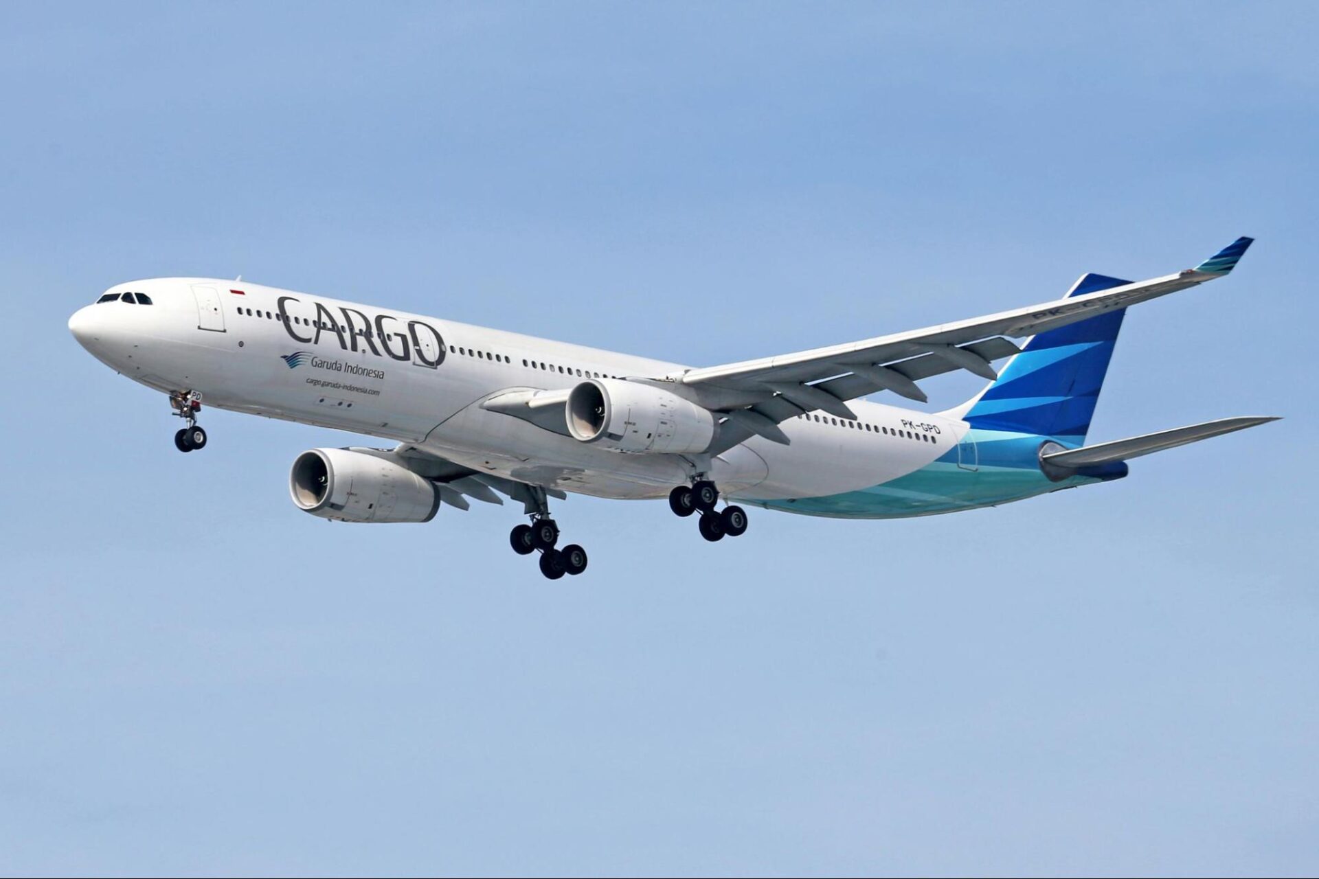 An airplane in the sky, with the word 'Cargo' across its side.